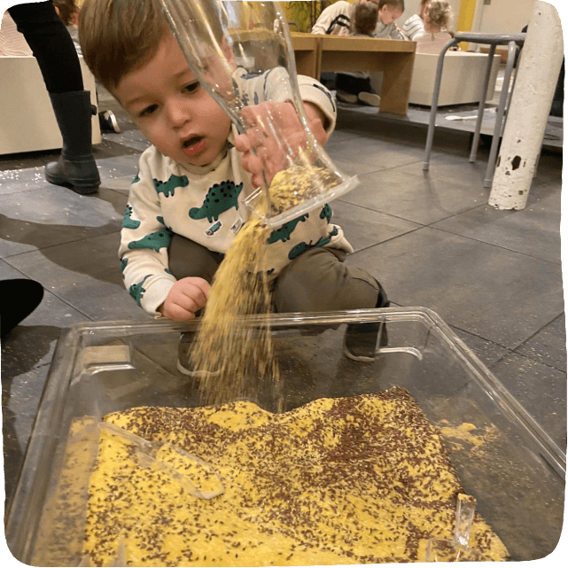 Little boy pouring dry corn into a bin