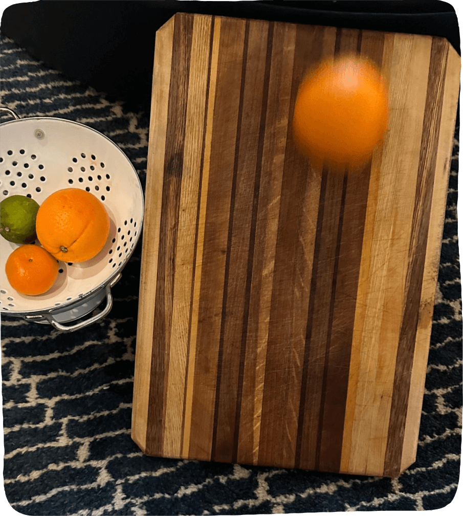 Image of a clementine rolling down a chopping board and a colander holding an orange, lime, and clementine. A perfect set up for this food activity for kids.