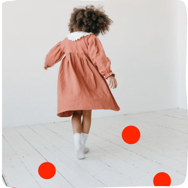 Little girl in pink dress with red dots on floor