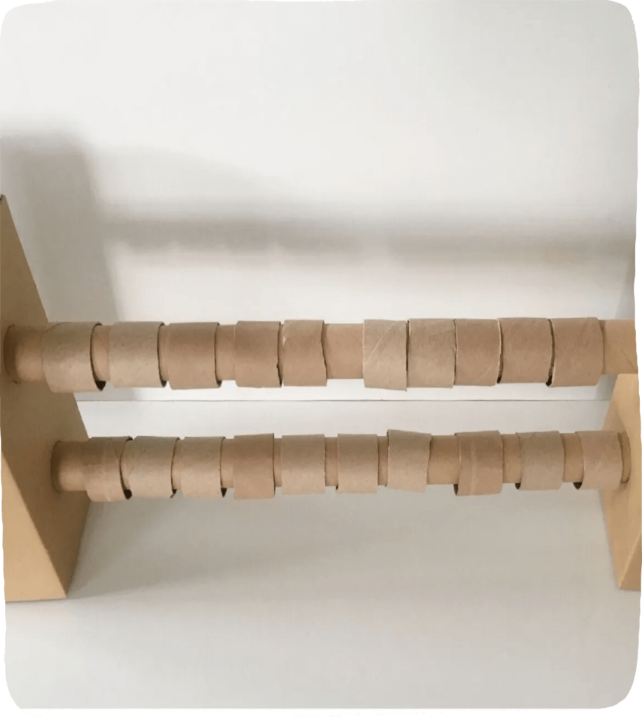 Image of sections of toilet paper rolls on a wooden dowel to construct a DIY abacus and make learning math fun.