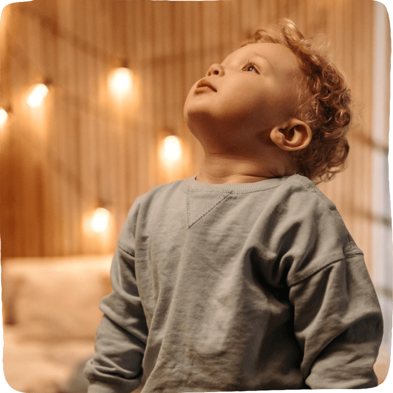 Image of a young child looking upwards in his room practicing a social-emotional strategy: Balloon breathing. 