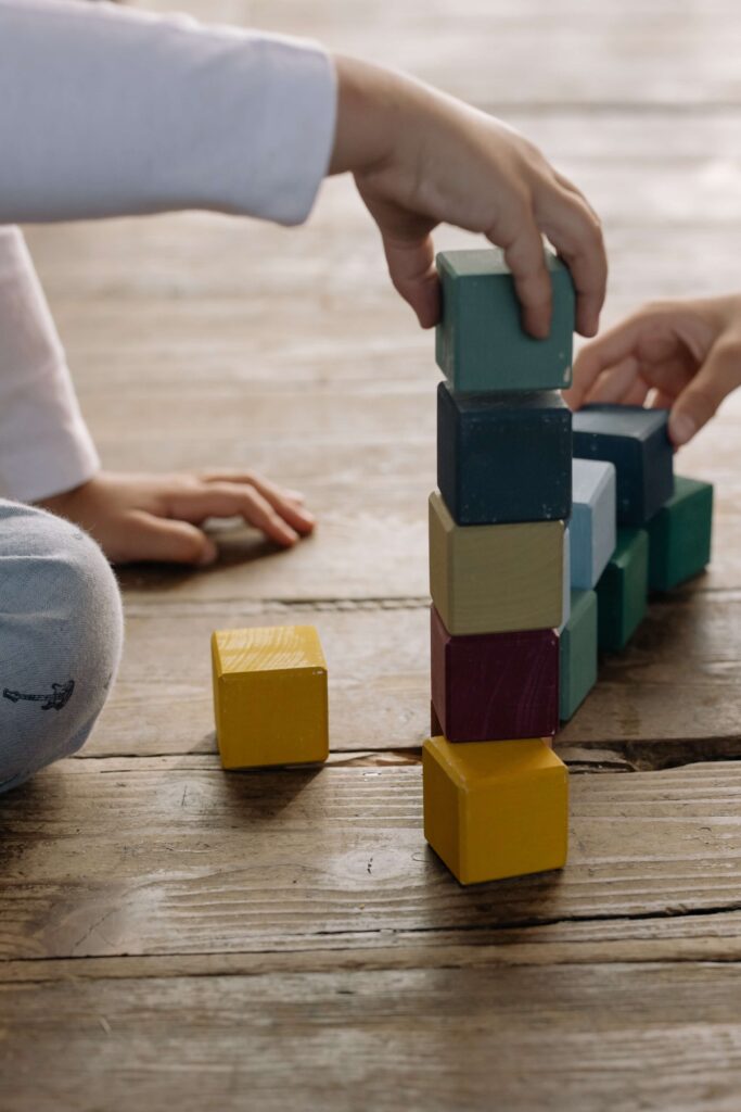 child's hand stacking blocks